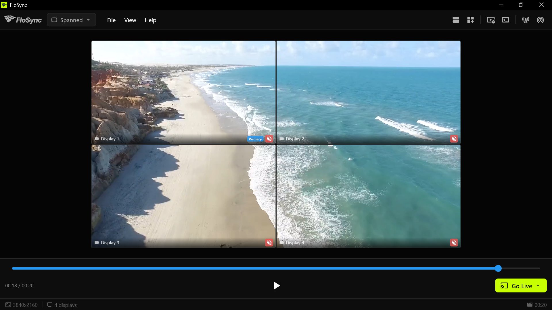 The control panel with the mode dropdown set to Spanned and four screen boxes in a two-by-two grid showing one continuous aerial view of a beach.