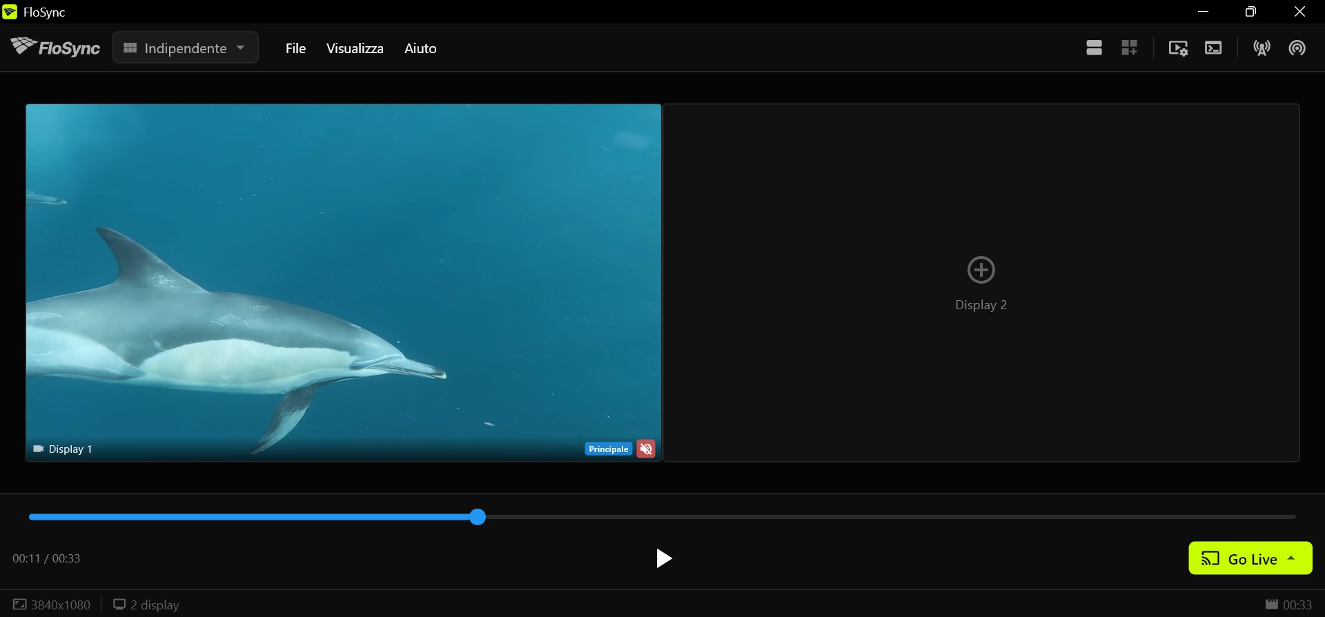 Il pannello di controllo di FloSync con un video di delfini su Display 1, un Display 2 vuoto che mostra un segno più, la timeline avanzata a circa un terzo, e i pulsanti play e Go Live nella barra inferiore.