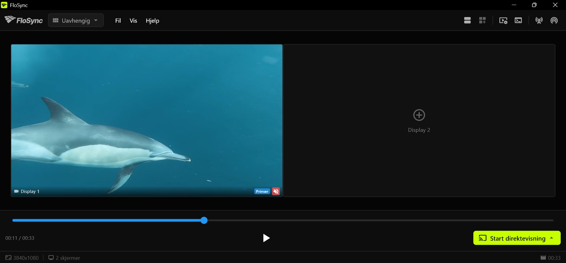FloSyncs kontrollpanel med en delfinvideo på Display 1, en tom Display 2 som viser et plusstegn, tidslinjen et stykke ute, og avspill- og Start direktevisning-knappene i bunnlinjen.