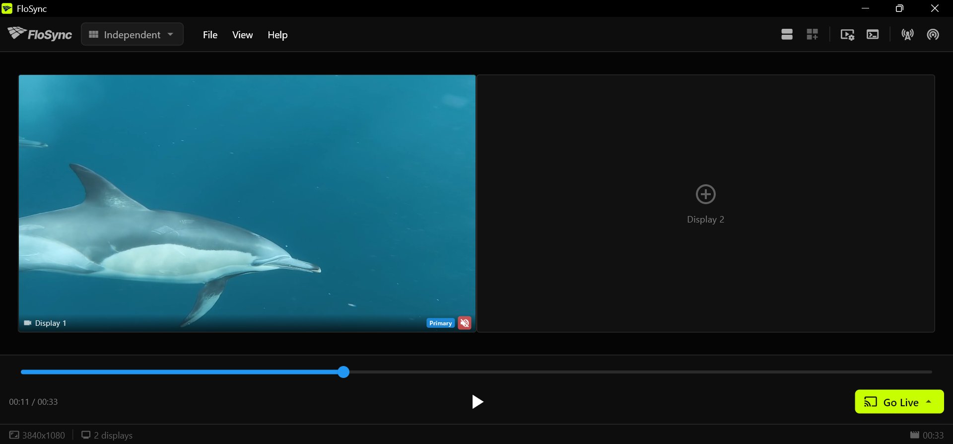 FloSync's control panel with a dolphin video on Display 1, an empty Display 2 showing a plus sign, the timeline partway along, and the play and Go Live buttons in the bottom bar.