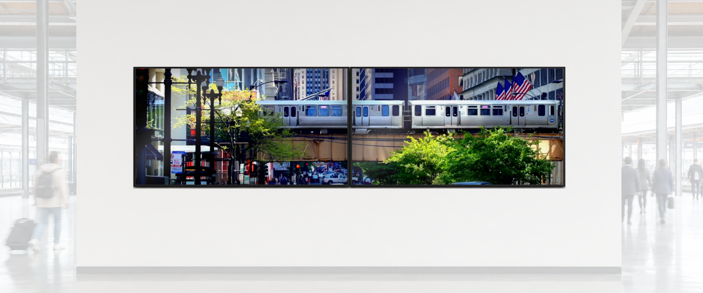 Two nearly-touching screens in a bright station concourse, ghosted passers-by in the foreground, playing the Chicago L train clip as one continuous picture