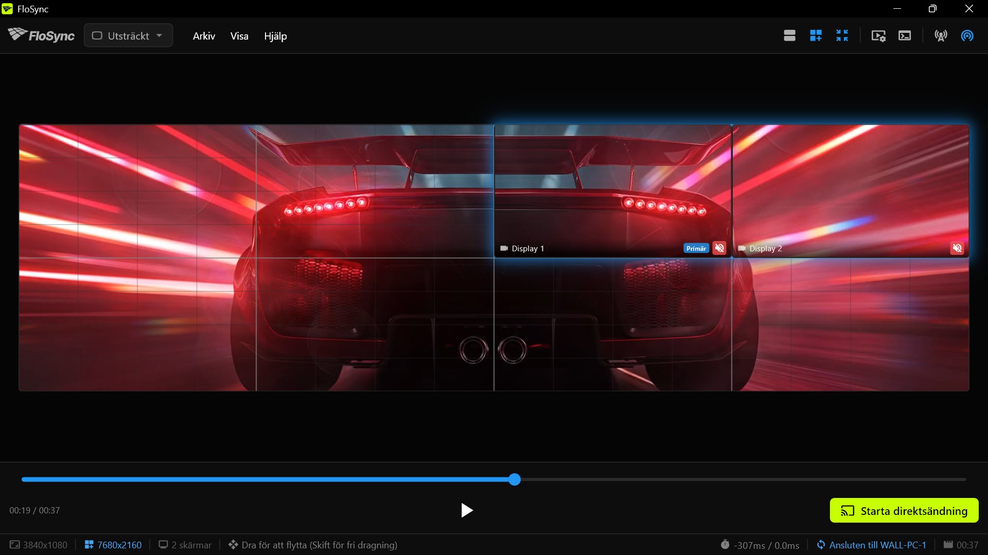 FloSyncs helväggsvy på PC 2 vid 00:19, med sportbilen sedd bakifrån över väggen och PC 2:s par markerat i den övre högra fjärdedelen