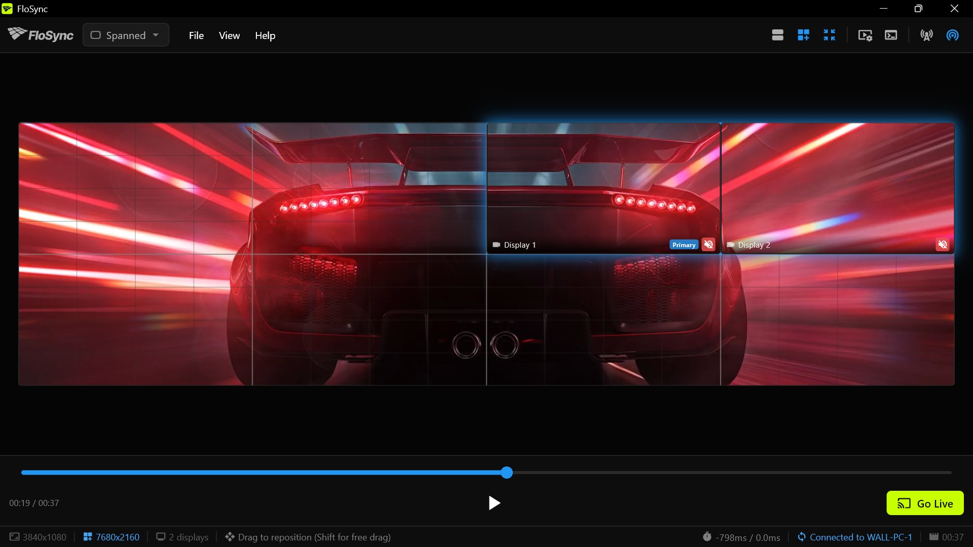 FloSync's whole-wall view on PC 2 at 00:19, the sports car seen from behind across the wall and PC 2's pair outlined in the top-right quarter